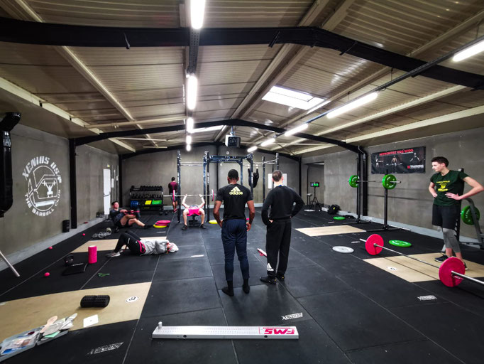 Séance de coaching sportif en petit groupe dans une salle équipée Xenios USA Barbell Club