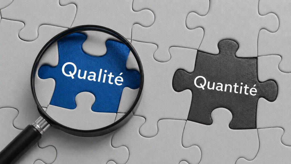 Qualité vs Quantité : choisir le bon curseur pour optimiser son entraînement en musculation Deux pièces de puzzle, l'une portant le mot "Qualité" mise en valeur par une loupe, l'autre "Quantité", illustrant le choix entre ces deux approches en musculation
